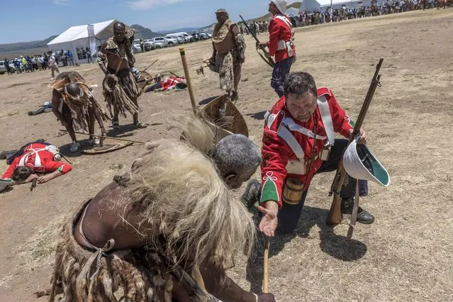 A member of the Amabutho Zulu regiments is congratulated by a member of the Dundee Diehards at the end of the Battle of Isandlwana, in Isandlwana on January 21, 2023. (Photo by Marco Longari/AFP Photo)