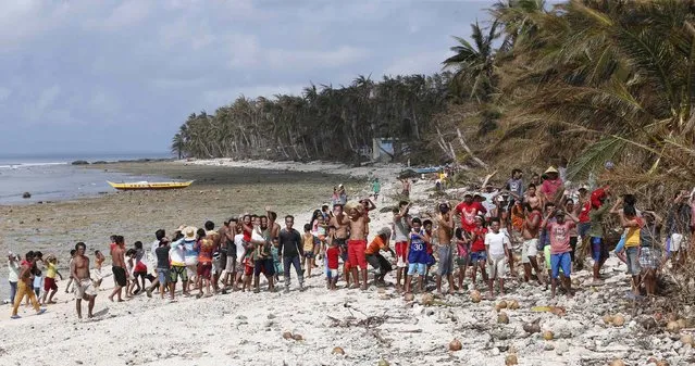 Typhoon victims wait for relief supplies on a beach in a remote village in Dolores, Eastern Samar, central Philippines December 9, 2014. (Photo by Erik De Castro/Reuters)