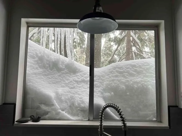 Snow is piled up against the kitchen window of Jennifer Cobb's house in Lake Arrowhead on Tuesday, February 28, 2023 in the San Bernardino Mountains of San Bernardino County, Calif. Beleaguered Californians got hit again Tuesday as a new winter storm moved into the already drenched and snow-plastered state, with blizzard warnings blanketing the Sierra Nevada and forecasters warning residents that any travel was dangerous. (Photo by Jennifer Cobb via AP Photo)