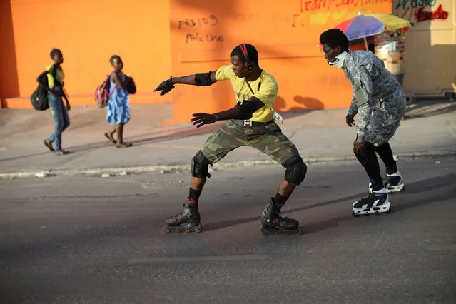 Youths skate down a street in Port-au-Prince, March 18, 2018. (Photo by Andres Martinez Casares/Reuters)