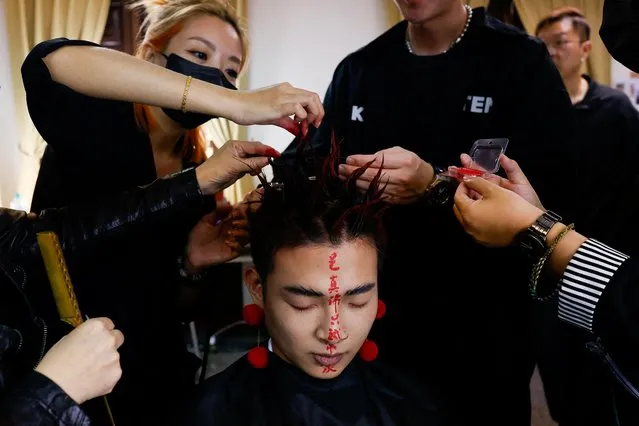 A model get his hair and makeup done before the opening show of Taipei Fashion week which highlight the mix of using traditional and fashion at Tainan, Taiwan on March 22, 2023. (Photo by Ann Wang/Reuters)