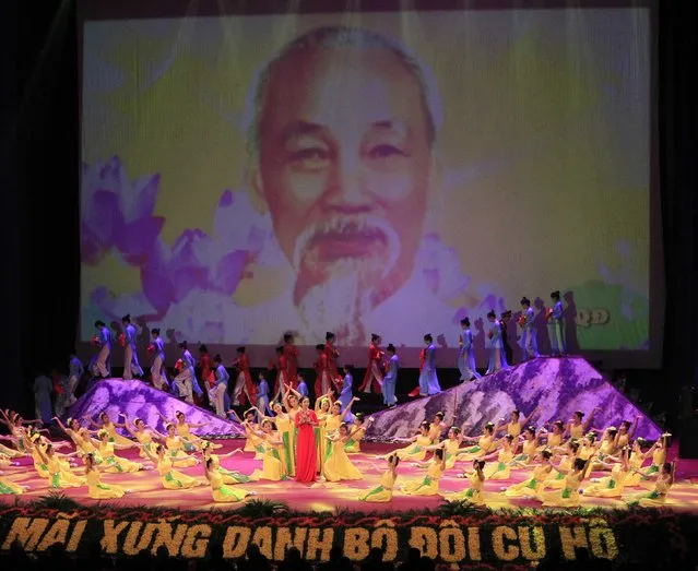 People perform in front of a screen showing an image of late revolutionary leader Ho Chi Minh during celebrations to commemorate the 70th anniversary of the establishment of the Vietnam People's Army at the National Convention Center in Hanoi December 20, 2014. (Photo by Reuters/Kham)