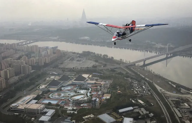An ultralight aircraft flies over the city of Pyongyang on Sunday, October 16, 2016, in North Korea. Until a few months ago, if you wanted a bird's eye view of North Korea's capital there was basically only one option: a 150-meter tall tower across the river from Kim Il Sung Square. Now, if you have the cash, you can climb into the backseat of an ultralight aircraft. With the support of North Korean leader Kim Jong Un, who has vowed to give North Koreans more modern and “cultured” ways to spend their leisure time, a Pyongyang flying club has started offering short flights over some of the capital's major sights. The flights are not cheap: A 25-minute ride from the airstrip on the outskirts of the city to Kim Il Sung Square and the Juche Tower, which had previously been the best place to get an urban panorama, goes for around $150. (Photo by Wong Maye-E/AP Photo)