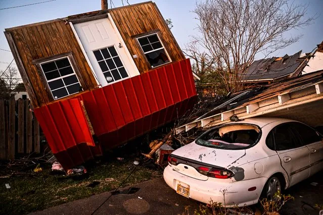 The remains of crushed house and cars are seen in Rolling Fork, Mississippi, on March 25, 2023, after a tornado touched down in the area. At least 25 people were killed by devastating tornadoes that ripped across the southern US state of Mississippi, tearing off roofs, smashing cars and flattening entire neighborhoods, with the region readying for more severe weather Sunday. The powerful weather system, accompanied by thunderstorms and driving rain, cut a path of more than 100 miles (60 kilometers) across the state late March 24, 2023, slamming several towns along the way. (Photo by Chandan Khanna/AFP Photo)