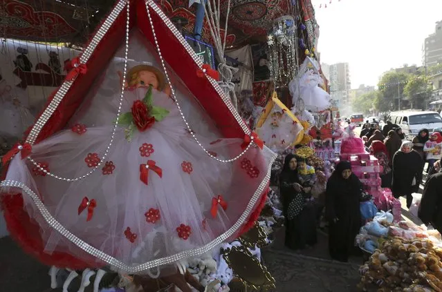 Women buy traditional sweets and doll toys for children to celebrate the birthday of prophet Muhammad, also known as “mawlid al nabi”, which will fall next week, in a makeshift tent in Cairo, December 30, 2014. (Photo by Mohamed Abd El Ghany/Reuters)