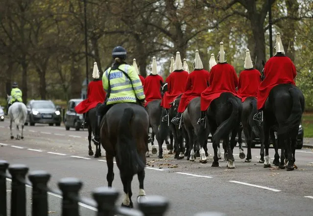 Members of the Household Cavalry are escorted by police as they ride through Hyde Park in London, Britain November 16, 2015. (Photo by Peter Nicholls/Reuters)