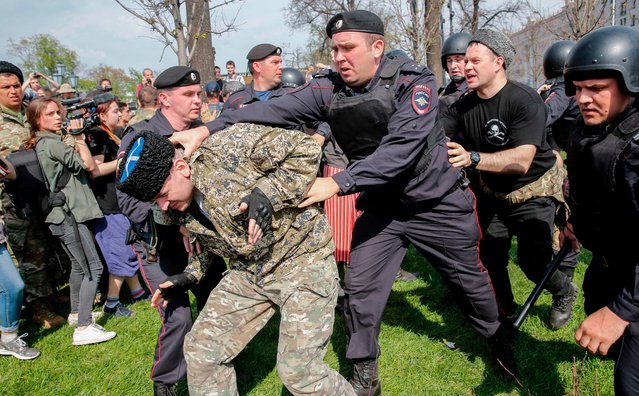 Russian police officers detain a cossack during an unauthorized anti- Putin rally called by opposition leader Alexei Navalny on May 5, 2018 in Moscow, two days ahead of Vladimir Putin' s inauguration for a fourth Kremlin term. (Photo by Maxim Zmeyev/AFP Photo)