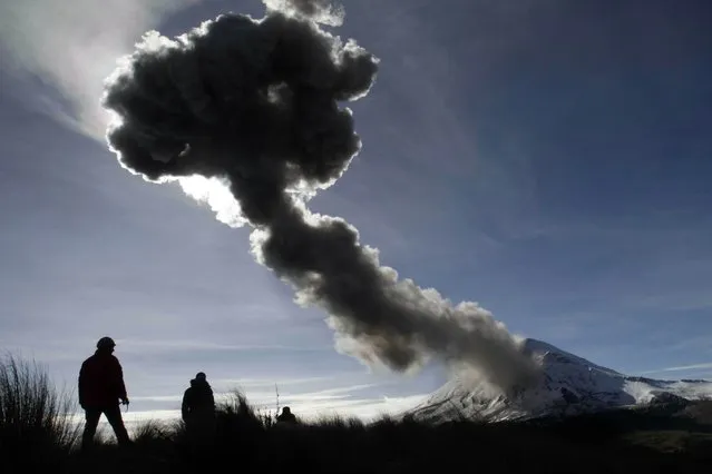 People look at the Popocatepetl volcano as it spews ash from the Paso de Cortes community, in Puebla State, Mexico on December 28, 2014. (Photo by Guadalupe Perez/AFP Photo)