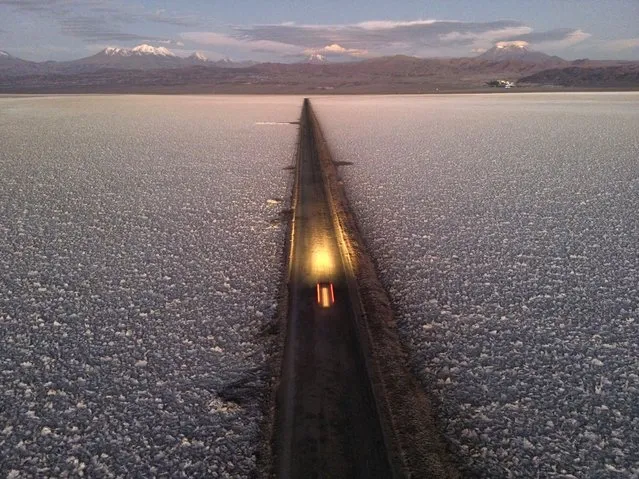 A car drives on a road through the Salar de Atacama near the Albemarle lithium mine in Chile, Monday, April 17, 2023. (Photo by Rodrigo Abd/AP Photo)