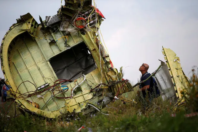 A Malaysian air crash investigator inspects the crash site of Malaysia Airlines Flight MH17, near the village of Hrabove (Grabovo) in Donetsk region, Ukraine, July 22, 2014. (Photo by Maxim Zmeyev/Reuters)