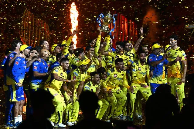 Chennai Super Kings' players celebrate with the trophy after their victory against Gujarat Titans in the Indian Premier League (IPL) Twenty20 final cricket match at the Narendra Modi Stadium in Ahmedabad on May 30, 2023. (Photo by Sajjad Hussain/AFP Photo)