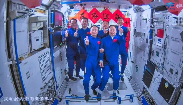 Crew of the Shenzhou-15 spaceflight mission Fei Junlong (front L), Zhang Lu (back L) and Deng Qingming (back 2nd L) take photos with crew of the Shenzhou-16 spaceflight mission Jing Haipeng (front R), Gui Haichao (back R) and Zhu Yangzhu (back 2nd R) inside the Chinese space station core module Tianhe on May 30, 2023. China sent three astronauts to its Tiangong space station on May 30, putting a civilian into orbit for the first time as it pursues plans to send a crewed mission to the Moon by 2030. (Photo by CNS via AFP Photo)