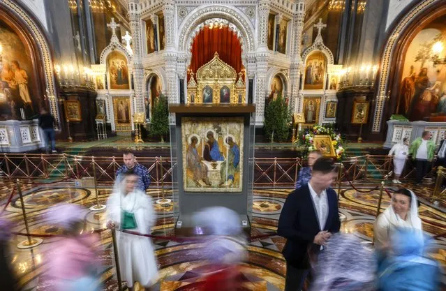 Russian Orthodox believers worship the icon “Trinity” by Andrei Rublev during a church service on Holy Trinity in the Cathedral of Christ the Savior in Moscow, Russia, 04 June 2023. On 15 May, it became known about the decision to transfer the icon “Trinity” by Andrei Rublev from the Tretyakov Gallery to the Russian Orthodox Church. According to the message, which was published on the website of the Russian Orthodox Church, the decision was made by the Russian president “in response to numerous requests from Orthodox believers”. On 16 May, the Russian Ministry of Culture reported that the icon would be exhibited in the Cathedral of Christ the Savior on 04 June, then sent for restoration, and then to the Trinity Cathedral of the Holy Trinity Sergius Lavra. At the same time, the department noted that the icon, which is part of the state museum fund of the Russian Federation, will be transferred to the Russian Orthodox Church for long-term safekeeping. (Photo by Sergei Ilnitsky/EPA/EFE)