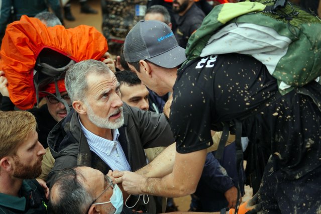 King Felipe VI of Spain (L) talks with a person as angry residents heckle him during his visit to Paiporta, in the region of Valencia, eastern Spain, on November 3, 2024, in the aftermath of devastating deadly floods. A delegation led by Spain's king and prime minister was heckled today as it visited the Valencia region hit by deadly floods, with some screaming "assassins" and others throwing mud, according to AFP journalists on the scene. King Felipe VI and Queen Letizia visited the town of Paiporta, one of the most affected by the floods that have killed more than 200 people, alongside Prime Minister Pedro Sanchez and other officials. (Photo by Manaure Quintero/AFP Photo)
