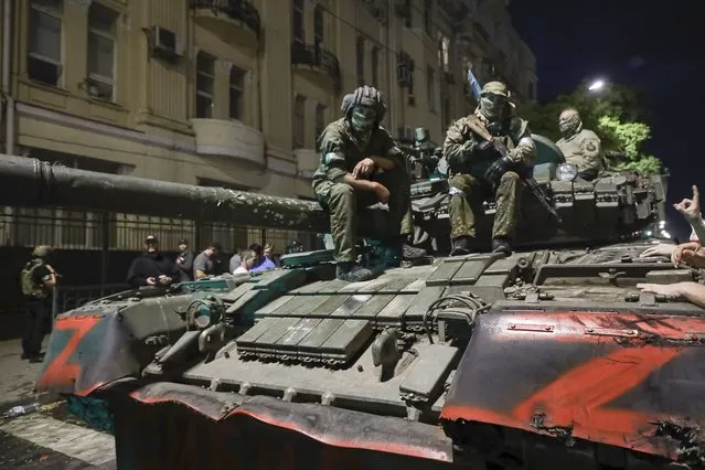 Membes of the Wagner Group military company sit atop of a tank on a street in Rostov-on-Don, Russia, Saturday, June 24, 2023, prior to leaving an area at the headquarters of the Southern Military District. Kremlin spokesman Dmitry Peskov said that Yevgeny Prigozhin's troops who joined him in the uprising will not face prosecution and those who did not will be offered contracts by the Defense Ministry. (Photo by AP Photo/Stringer)