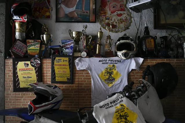 Awards and medals won by motorcycle stuntman Pedro Aldana sit on a wall at his home in the Catia neighborhood of Caracas, Venezuela, Thursday, January 21, 2021. The 33-year-old makes a living with his shows inspiring his young fans who flock to his shop, where he teaches them to change the oil and tune up their bicycles. (Photo by Matias Delacroix/AP Photo)