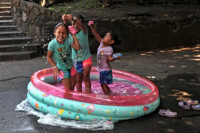 Children play in an inflatable pool on a sidewalk during hot weather outside Richman (Echo) Park in the Bronx borough of New York City, U.S., July 20, 2023. (Photo by Shannon Stapleton/Reuters)