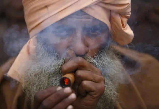 Hindu holy man, or sadhu, smokes marijuana with a chillum on the premises of Pashupatinath Temple in Kathmandu February 15, 2015. (Photo by Navesh Chitrakar/Reuters)