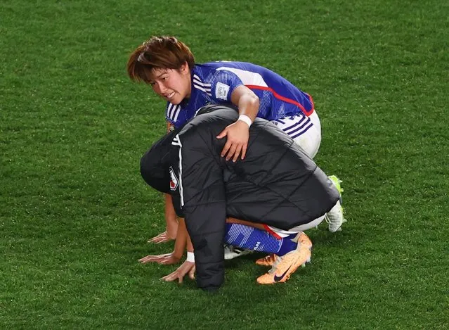 Japan's defender #12 Hana Takahashi consoles a teammate after being knocked out of the World Cup during the Australia and New Zealand 2023 Women's World Cup quarter-final football match between Japan and Sweden at Eden Park in Auckland on August 11, 2023. (Photo by Hannah Mckay/Reuters)