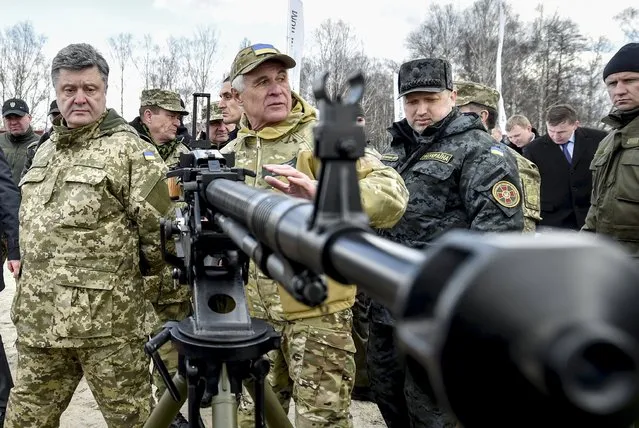 Ukraine's President Petro Poroshenko (L) and Ukrainian secretary to the National Security and Defence Council Oleksandr Turchynov (3rd L) inspect weapons and military equipment as they visit the training center of the Ukrainian National Guard outside Kiev April 4, 2015. (Photo by Mykola Lazarenko/Reuters/Ukrainian Presidential Press Service)