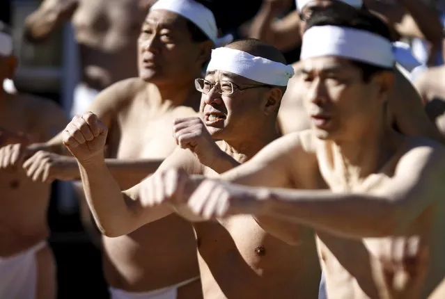 Men wearing the traditional "fundoshi" or loincloth warm up before bathing in ice-cold water at the Teppozu Inari shrine in Tokyo, Japan, January 10, 2016. (Photo by Yuya Shino/Reuters)