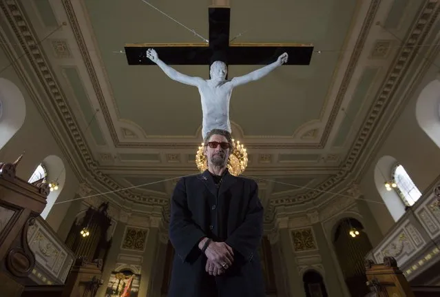 Artist Nick Reynolds poses next to his work “For Pete's Sake”, a life size sculpture of a musician Pete Doherty crucified,  which is hanging from the ceiling at St Marylebone Parish church in London, February 19, 2015. (Photo by Neil Hall/Reuters)