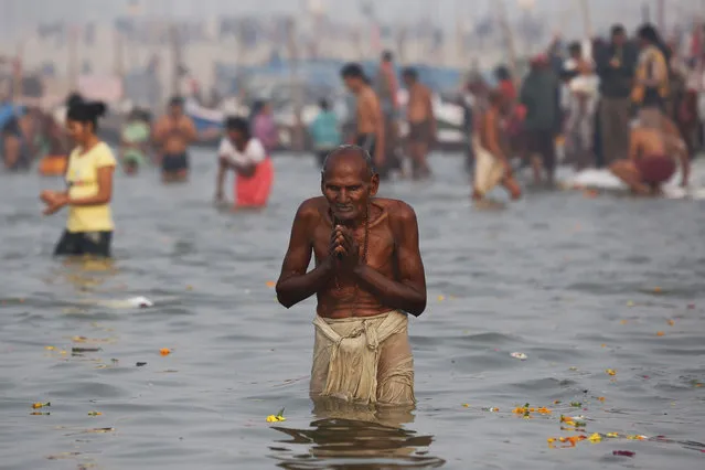 An Indian Hindu devotee takes a dip at Sangam, the confluence of the Ganges, Yamuna and mythical Saraswati River, during the Makar Sankranti festival in Allahabad, India, Friday, January 15, 2016. Makar Sankranti marks the beginning of the sun's northward movement according to the solar calendar and considered to be auspicious. (Photo by Rajesh Kumar Singh/AP Photo)
