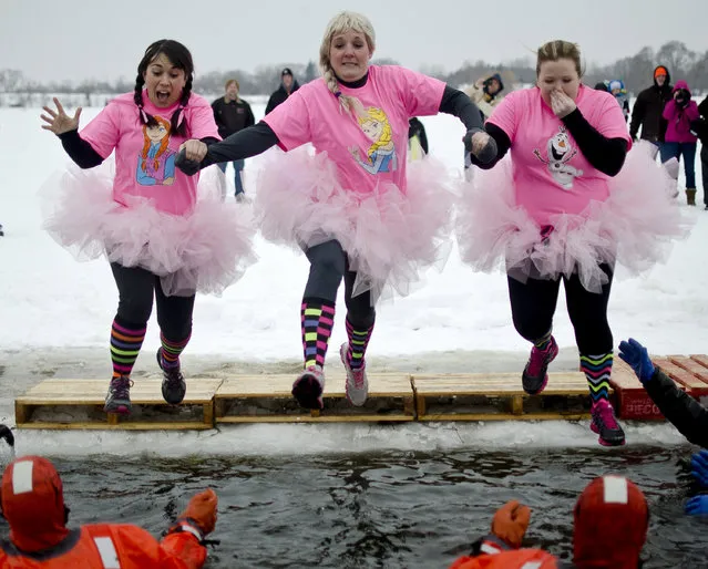 Sarah Zimmerman, left, Melissa Courier, middle, and Amanda Young, right jump into the pond at the William H. Haithco Recreation Area during the Michigan Law Enforcement Polar Plunge for Special Olympics, Saturday, February 21, 2015, in Saginaw Township, Mich. (Photo by Andrew Whitaker/AP Photo/The Saginaw News)