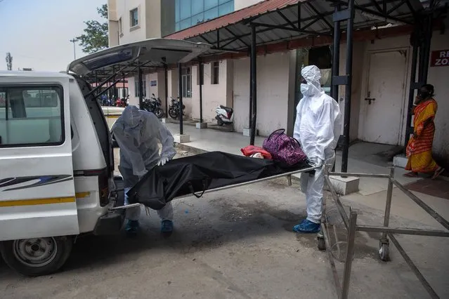 Health workers in protective suits shift the body of a COVID-19 victim at a government hospital in Gauhati, India, Monday, May 24, 2021. (Photo by Anupam Nath/AP Photo)