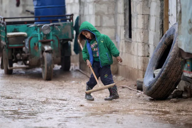 An internally displaced Syrian girl removes rainwater in the Bab Al-Salam refugee camp, near the Syrian-Turkish border, northern Aleppo province, Syria December 26, 2016. (Photo by Khalid al Mousily/Reuters)