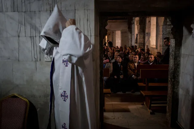 People wait for the start of Christmas mass at the Mar Shimoni Church on December 24, 2016 in Bartella, Iraq. The predominantly Christian town of Bartella was recently liberated from ISIL as part of the Mosul offensive. The town's four churches were heavily damaged and defaced during the two year occupation. The Christmas mass marks the first official mass in Bartella since a mass was held on Aug. 14, 2014 just hours before ISIS arrived. Christian communities around Mosul are celebrating Christmas as the Mosul offensive continues. (Photo by Chris McGrath/Getty Images)