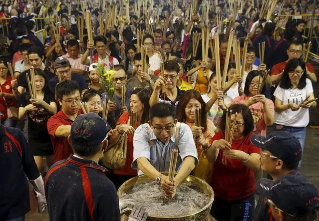 People rush to plant the first joss stick of the Lunar New Year of the Monkey at the stroke of midnight at the Kwan Im Thong Hood Cho temple in Singapore February 8, 2016. (Photo by Edgar Su/Reuters)