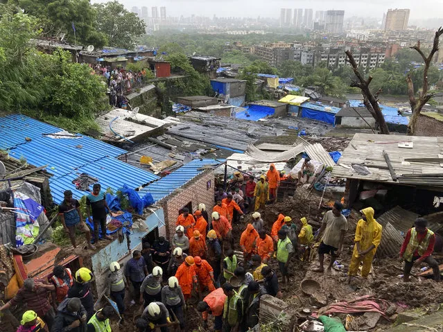 Rescuers perform search operation after a wall collapsed on several slum houses heavy monsoon rains in the Mahul area of Mumbai, India, Sunday, July 18, 2021. More than a dozen people were killed in the incident. (Photo by Rajanish Kakade/AP Photo)
