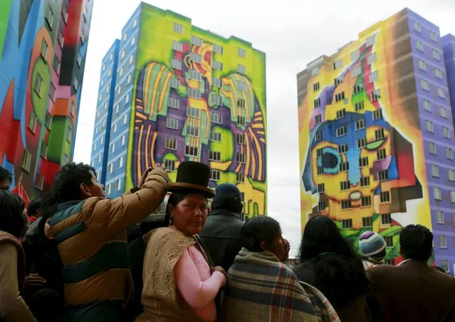 People attend the inauguration of multifamily buildings decorated by painter Roberto Mamani and built by a housing program of Bolivia's President Evo Morales' government in El Alto, on the outskirts of La Paz, Bolivia, February 15, 2016. (Photo by David Mercado/Reuters)