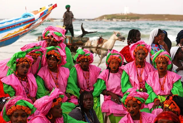 Fishing boats (Pirogue) compete in a race as Senegalese people wearing traditional face paints and clothes, perform dances belonging to ethnic group “Lebu” settled in Yoff village, during the 4th Dakar Carnival where they celebrate their cultural richness and expressing the diversity of traditional and modern cultural heritage at Kossoupe Beach in Dakar, Senegal on November 26, 2023. (Photo by Cem Ozdel/Anadolu via Getty Images)