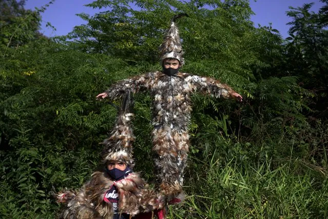 Lucas, 7, left, and his 9-year-old brother Josias, pose for a portrait wearing their feathered costumes during the feast of St. Francis Solano, in Emboscada, Paraguay, Saturday, July 24, 2021. According to their mother they are taking part in the festivities to honor a promise she made to the 16th century Spanish patron saint for their good health amid the new coronavirus pandemic. (Photo by Jorge Saenz/AP Photo)