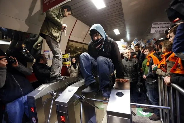 A demonstrator jumps over a turnstile during a protest against private security guards at Taksim metro station in central Istanbul December 31, 2013. Hundreds of left-wing demonstrators gathered at Istanbul and Ankara main metro stations to protest against private security guards working at metro stations. Aykut Kelek, a 20-year-old man, who attempted to board the metro without paying in Istanbul was beaten by a security guard and hospitalized on Monday, local media reported. (Photo by Murad Sezer/Reuters)