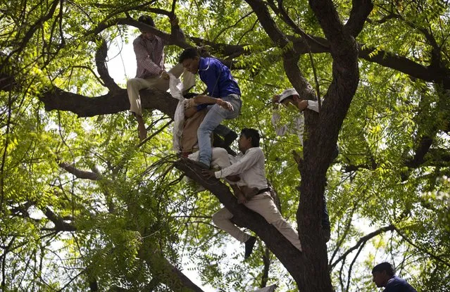 Volunteers of the Aam Admi Party try to rescue Gajendra Singh, who hanged himself during a farmer's rally in New Delhi, India, Wednesday, April 22, 2015. According to a note he left behind and which police recovered, Singh killed himself after his father, left with nothing after rainstorms destroyed their crops, forced him from the family home. It was the latest in a wave of suicides that has left at least 40 farmers dead in recent weeks. (Photo by Saurabh Das/AP Photo)