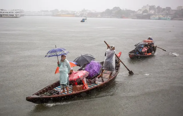 Bangladeshi passengers cross the Buriganga River during the heavy rain as Cyclone Midili affects the costal area, in Dhaka, Bangladesh on November 17, 2023. According to Bangladesh Meteorological Department (BMD) and the Bangladesh Inland Water Transport Authority (BIWTA) the cyclone Midili is likely to move north-northeastward further and may complete crossing the coast by 17 November evening and all type of river vessels operations were suspended due to the cyclonic storm. (Photo by Monirul Alam/EPA/EFE)