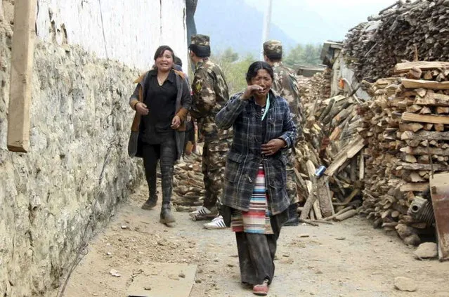 Residents cry as they walk past damaged houses to safer areas, after a 7.9 magnitude earthquake hit Nepal, in Gyirong county of Xigaze Prefecture, Tibet Autonomous Region, China, April 25, 2015. (Photo by Reuters/Stringer)