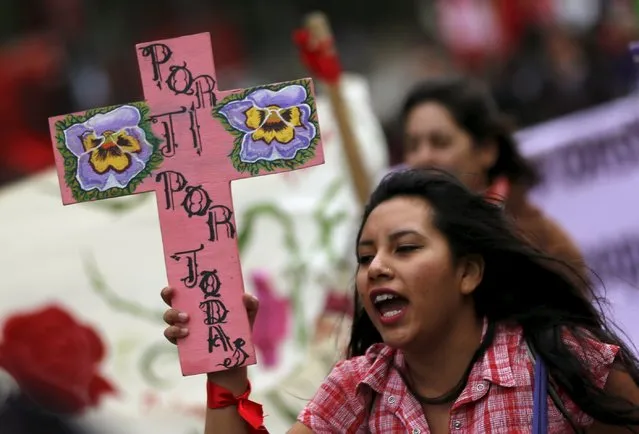 A student carries a cross that reads in Spanish “For you, for all” next to other activists and women during a march to mark International Women's Day along the streets in Mexico City, Mexico, March 8, 2016. (Photo by Henry Romero/Reuters)