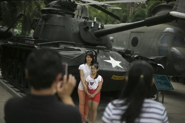Visitors have their photos taken near a tank used by the U.S. Army during the Vietnam War at the War Remnants Museum in Ho Chi Minh City, Vietnam, Wednesday, April 29, 2015. The city, formerly known as Saigon, is set to celebrate the 40th anniversary of the end of the Vietnam War on April 30. (Photo by Dita Alangkara/AP Photo)