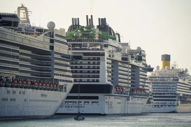A view of the MSC Grandiosa cruise ship, center, in Civitavecchia, near Rome, Wednesday, March 31, 2021. MSC Grandiosa, the world's only cruise ship to be operating at the moment, left from Genoa on March 30 and stopped in Civitavecchia near Rome to pick up more passengers and then sail toward Naples, Cagliari, and Malta to be back in Genoa on April 6. For most of the winter, the MSC Grandiosa has been a lonely flag-bearer of the global cruise industry stalled by the pandemic, plying the Mediterranean Sea with seven-night cruises along Italy’s western coast, its major islands and a stop in Malta. (Photo by Andrew Medichini/AP Photo)