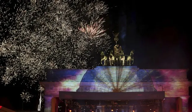 Berlin's famous landmark “Brandenburg Gate” is illuminated during the New Year's Eve celebrations in Berlin, Germany, Saturday, December 31, 2022. (Photo by Michael Sohn/AP Photo)