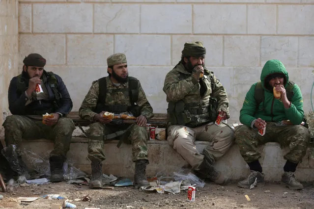 Rebel fighters eat while resting on the outskirts of the northern Syrian town of al-Bab, Syria February 8, 2017. (Photo by Khalil Ashawi/Reuters)