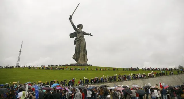 People take part in the Immortal Regiment march during the Victory Day celebrations at the Mamayev Kurgan (Mamayev Hill) World War Two memorial complex, with the statue of Mother Homeland seen in the background, in Volgograd, Russia, May 9, 2015. (Photo by Reuters/Host Photo Agency/RIA Novosti)