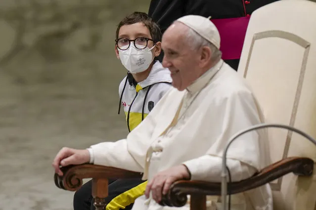 Pope Francis talks with a 10-year-old boy Paolo Junior, family name not available, after he unexpectedly walked up to him at the beginning of a weekly general audience in the Pope Paul VI hall at the Vatican, Wednesday, October 20, 2021. (Photo by Alessandra Tarantino/AP Photo)