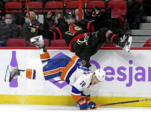 Ottawa Senators left wing Tim Stutzle (18) and New York Islanders left wing Anthony Beauvillier (18) fall after a hit during second period NHL hockey action in Ottawa, on Tuesday, December 7, 2021. 9Photo by Justin Tang/The Canadian Press via AP Photo)