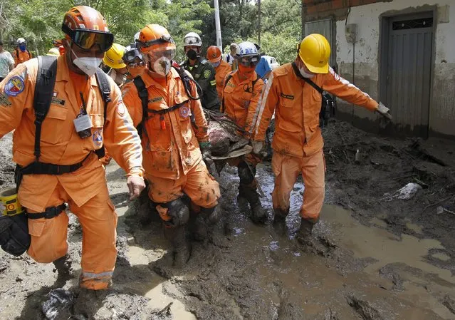 Rescue workes carry the body of a victim, after a landslide in the municipality of Salgar, in Antioquia department, May 19, 2015. (Photo by Fredy Builes/Reuters)