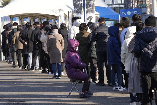 People queue in line to wait for the coronavirus testing at a makeshift testing site in Seoul, South Korea, Wednesday, December 8, 2021. (Photo by Ahn Young-joon/AP Photo)